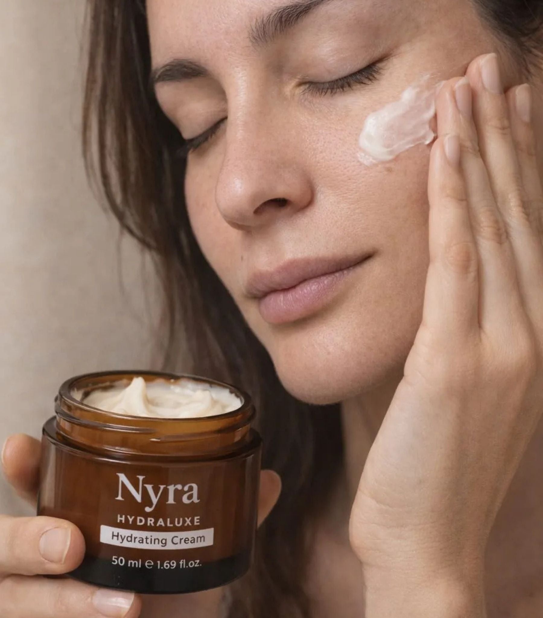 Mujer aplicando crema hidratante botánica Nyra Hydraluxe en piel sensible